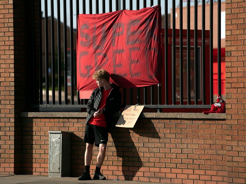 A member of the public stands by a banner outside Liverpool's Anfield Stadium protesting the formation of the European Super League.