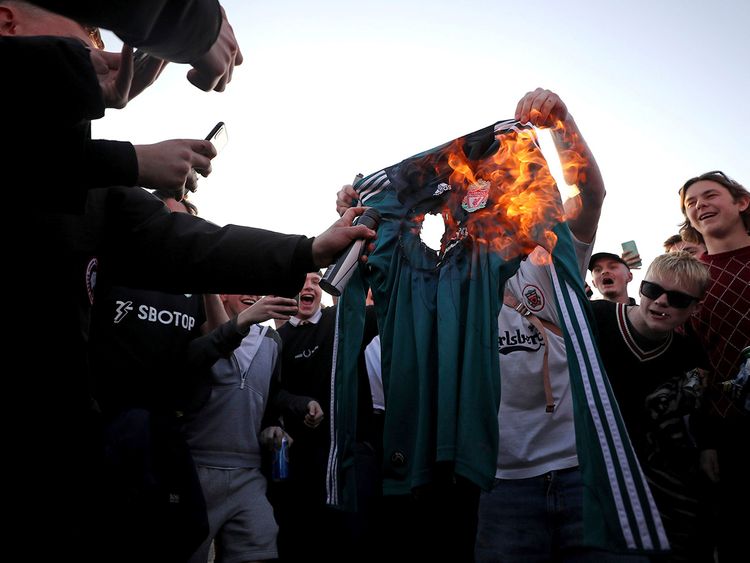 Fans burn replica Liverpool shirt in protest of the European Super League, announced Monday.