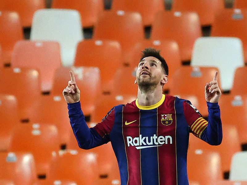 Messi celebrates two goals against Valencia as Barcelona wins 3-2.
