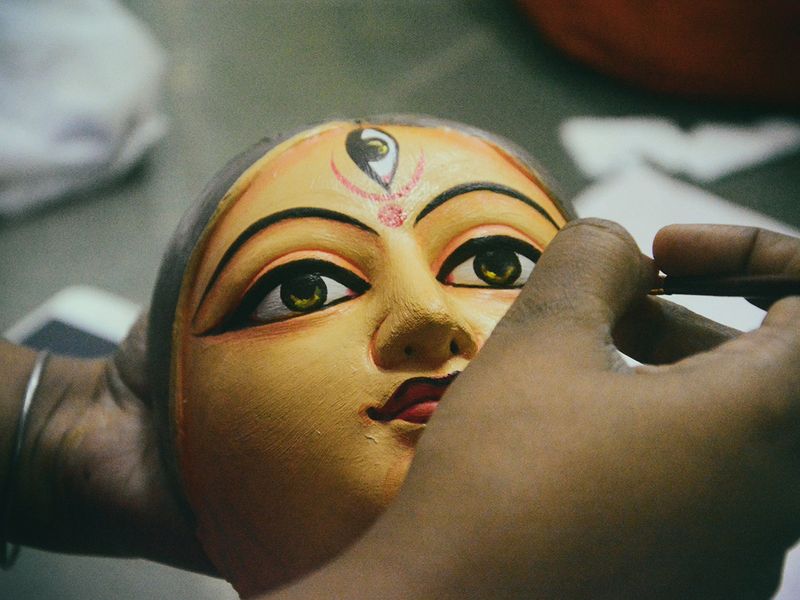 An artist painting the idol of goddess Durga for a popular festival - Durga pooja in Bengal