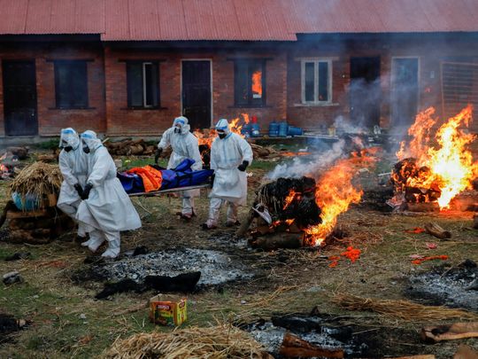 Members of Nepal Army in personal protective equipment (PPE) carry a body of a person, who died from the coronavirus disease (COVID-19), at the crematorium, in Kathmandu, Nepal May 11, 2021.