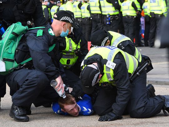 Police make an arrest as Rangers fans celebrate in George Square in Glasgow