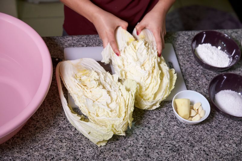 Cut the napa cabbage lengthwise, wash the leaves and soak in coarse salt.