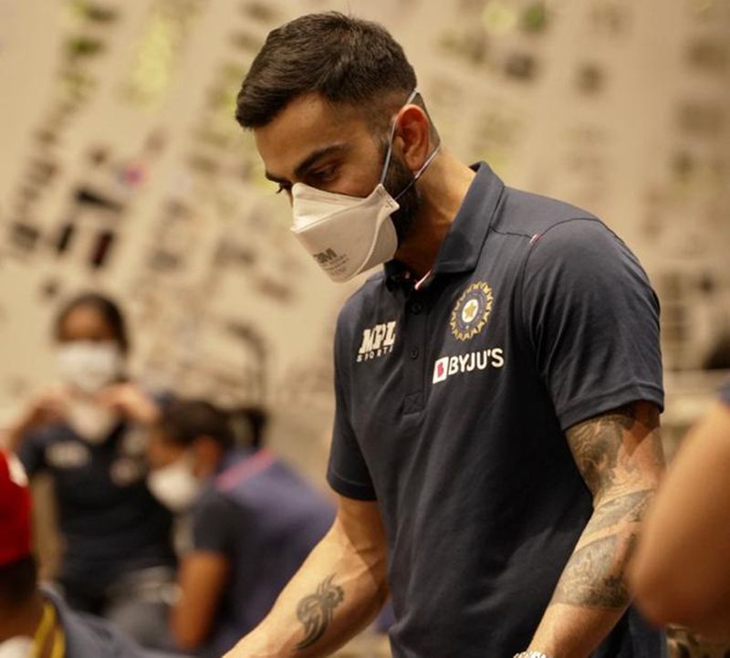 Off we go: Indian men's captain Virat Kohli, all masked up, at the Mumbai airport in the wee hours of Thursday night. Both men and women's teams took a charter flight to embark on a challenging mission. Image Credit: Twitter/BCCI
