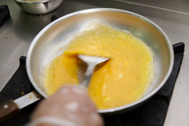 Mix using a spatula till large curds form, scrambled eggs should have a creamy texture, according to Chef Sanjeev.