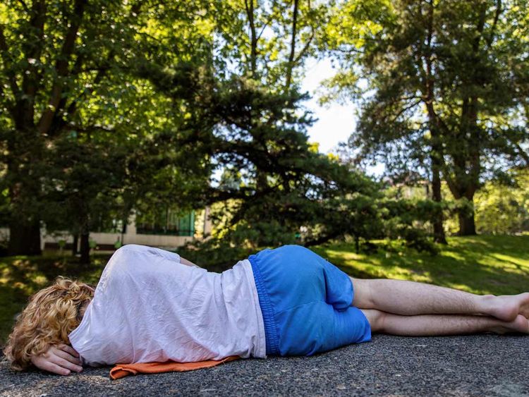 A young man naps in the shade during an unprecedented heat wave in Portland, Oregon. 