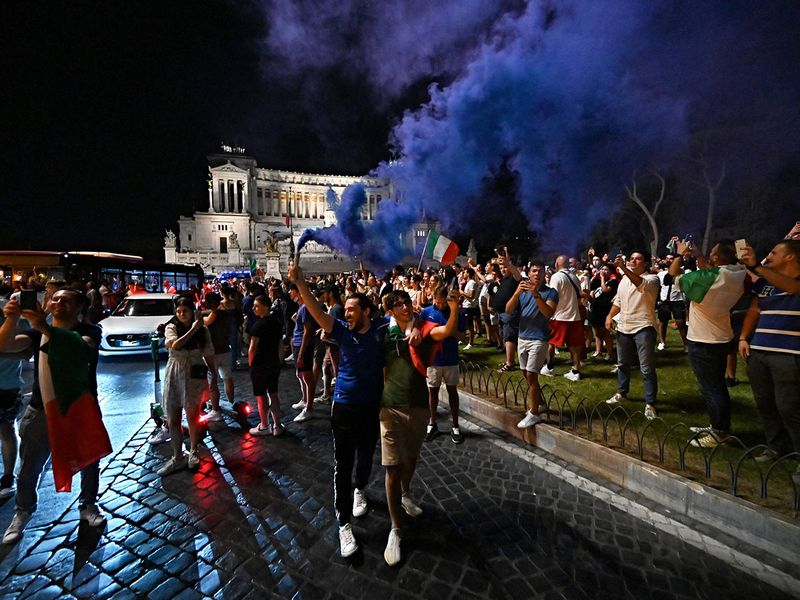 Supporters of Italy's national football team celebrate defeating Spain