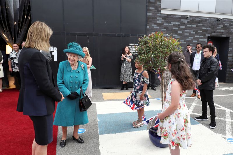 Britain's Queen Elizabeth meets actors and members of the production team during a visit to the set of the long running television series 'Coronation Street', in Manchester, Britain, July 8, 2021. 
