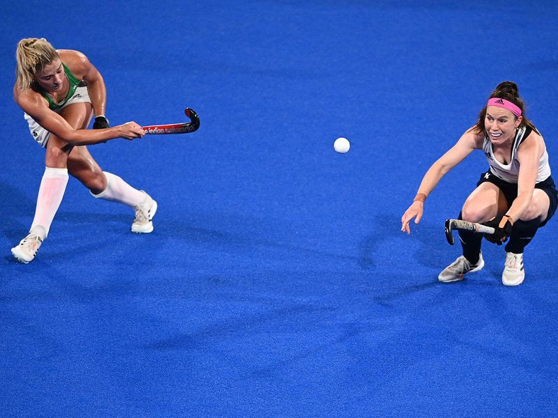 Ireland's Chloe Watkins strikes the ball as Great Britain's Laura Unsworth takes evasive action