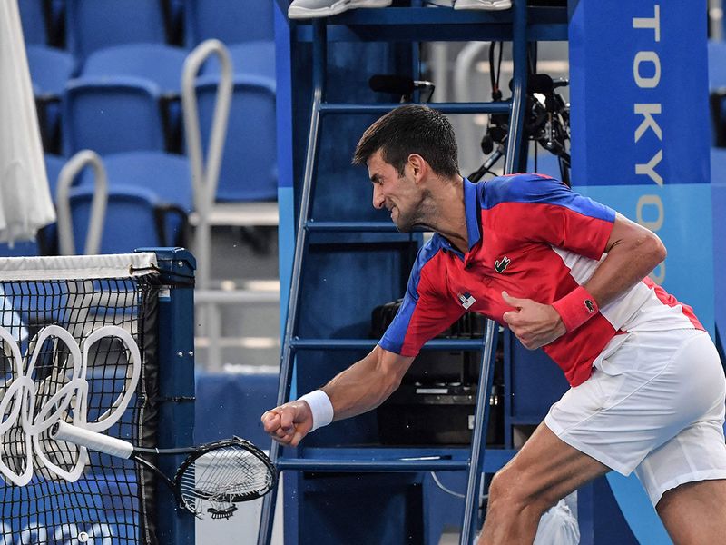 Novak Djokovic smashes his racket in the bronze medal match against  Pablo Carreno Busta 