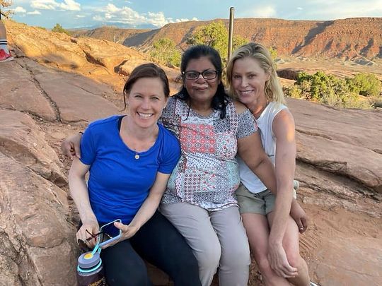 In this Tuesday, Aug. 3, 2021, photo provided by Shaji John, John's wife, Minnie John, center, poses with actress Julie Bowen, right, and Bowen's sister, Dr. Annie Luetkemeyer, left, after the pair cared for her after she fainted and hit her head on a rock while stopping to rest in Arches National Park, Utah. (Shaji John via AP)