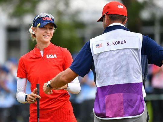 USA's Nelly Korda celebrates winning the gold medal with her caddie 