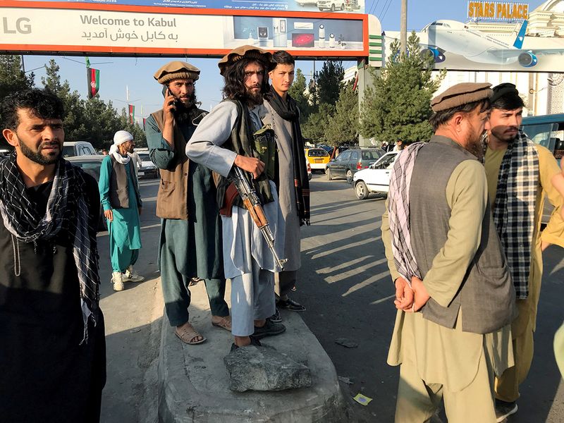 A member of Taliban (C) stands outside Hamid Karzai International Airport in Kabul, on August 16, 2021. 