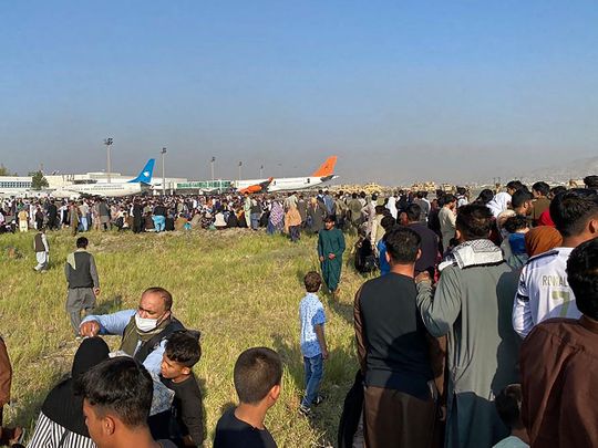 Afghans crowd at the airport as they wait to leave from Kabul on August 16, 2021.  