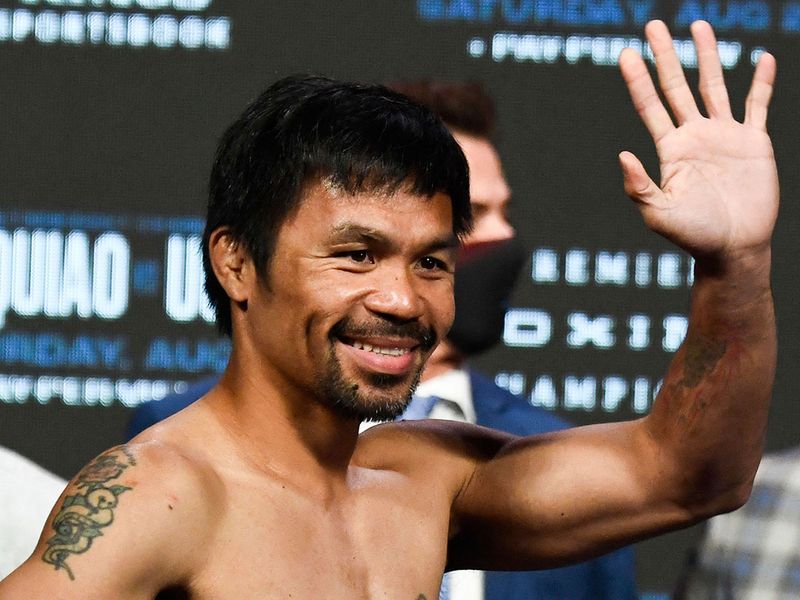 Manny Pacquiao waves after the weigh-in before his fight against WBA welterweight champion Yordenis Ugas 