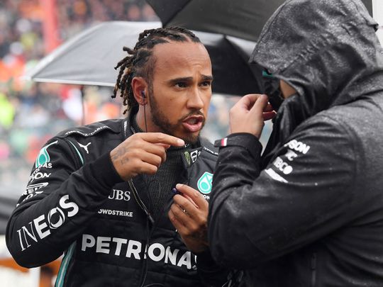 Mercedes' Lewis Hamilton waits in the rain ahead of the Belgian Grand Prix at Spa-Francorchamps