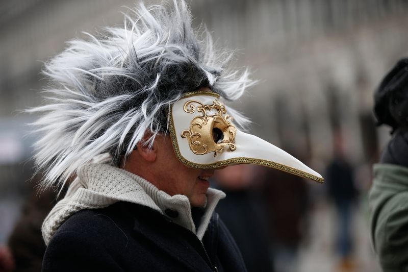 In this Jan. 24, 2016 file photo, a man wears a pest doctor mask in St. Mark’s Square in Venice, Italy. This carnival mask derives from 16th century doctors wearing beak-nosed masks filled with aromatic herbs to cleanse the air they breathed when treating the sick