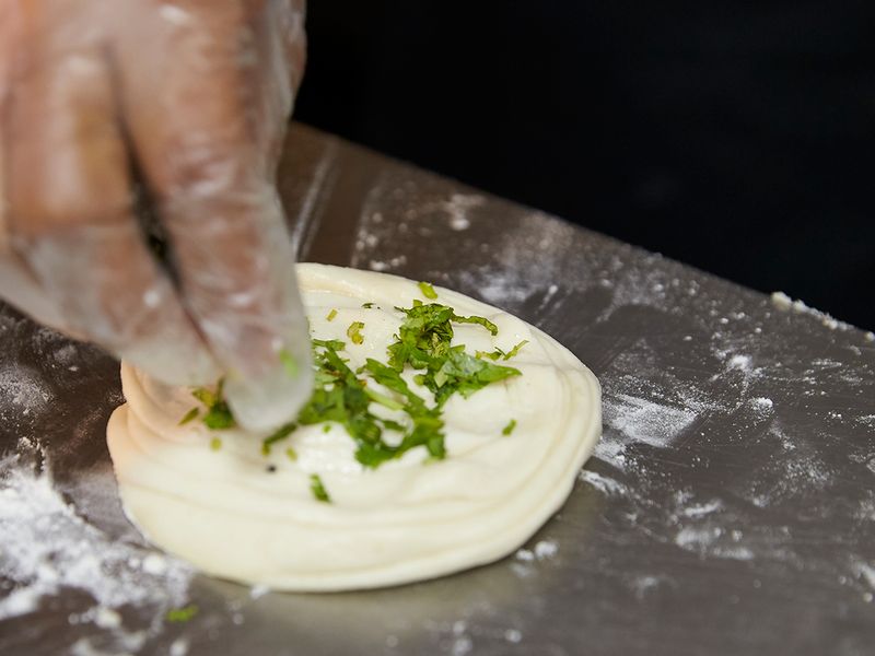 Sprinkle some coriander leaves on the dough 