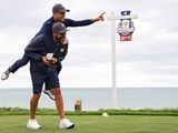 Team US star Justin Thomas jumps on caddie Michael Greller during practice for the Ryder Cup