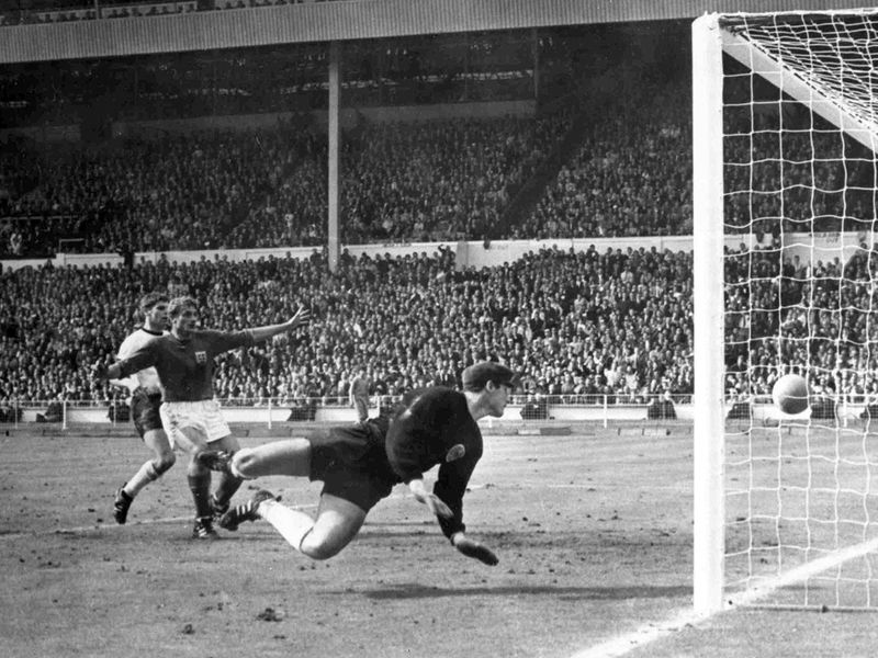 England's Roger Hunt raises his arms as Geoff Hurst scores England's third goal against West Germany