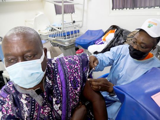 An Ivorian traditional chief receives a COVID-19 vaccine in a truck at a mobile vaccination center in Abidjan, Ivory Coast. 