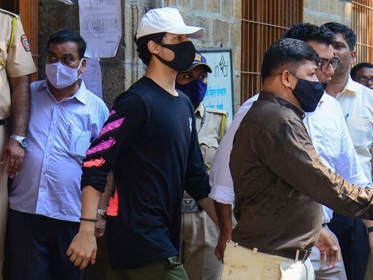 Aryan Khan (C), son of Bollywood actor Shah Rukh Khan, is escorted to court by Narcotics Control Bureau (NCB) officials for a bail plea hearing in Mumbai on October 7, 2021, after his arrest in connection with a drug case. (Photo by Sujit JAISWAL / AFP)