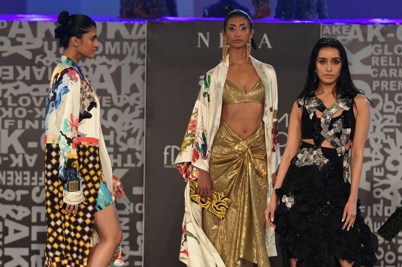 Bollywood actor and show stopper Shraddha Kapoor (right) presents a creation by designer Anamika Khanna during the ‘FDCI x Lakme Fashion Week’ fashion show in Mumbai on October 9, 2021