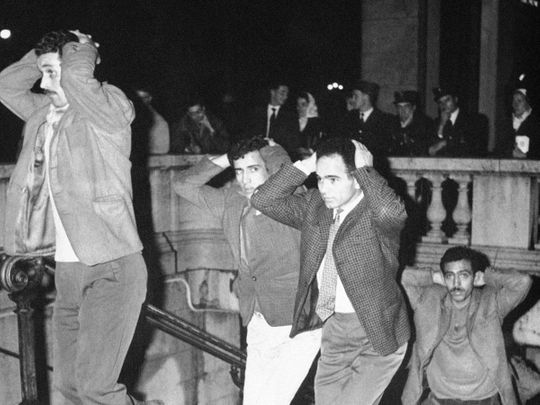  In this Oct.17, 1967 file photo, Algerians come out of Paris subway station with their hands on their heads after being arrested in Paris for failure to obey curfew imposed on Algerians. 