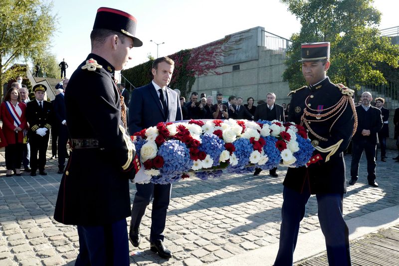 French President Emmanuel Macron lays a wreath near the Pont de de Bezons, Bezons bridge, during a ceremony commemorating the 60th anniversary of the massacre of October 17, 1961, a murderous repression by the French police, of a demonstration of Algerians in Paris, in the frame of a violent decolonisation process, in Colombes near Paris, France, October 16, 2021. 