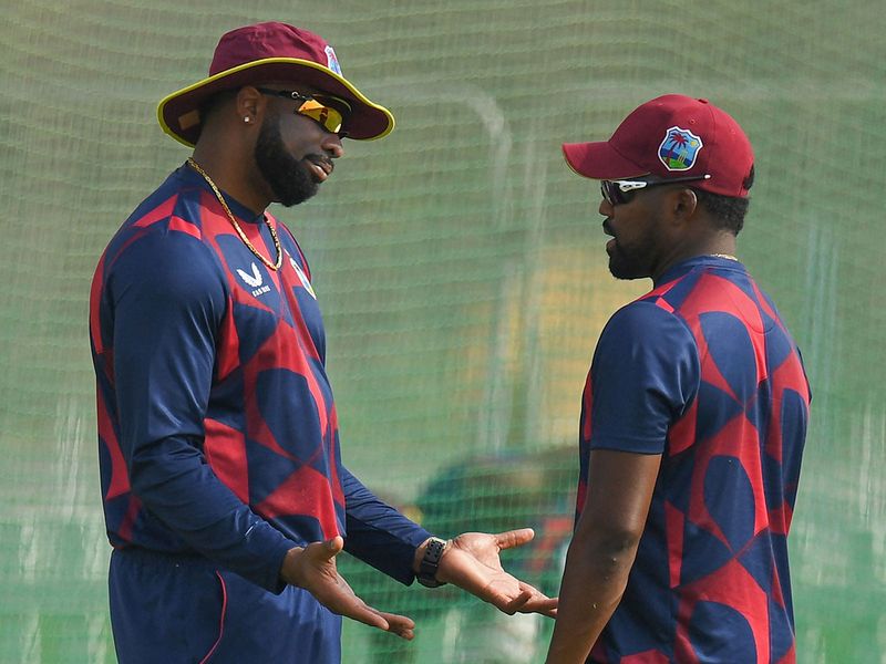 West Indies' Kieron Pollard speaks with his teammate Obed McCoy 