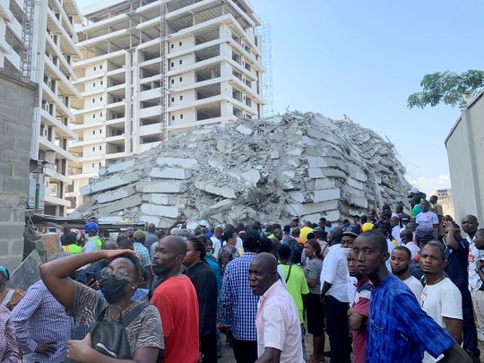 People gather at the site of a collapsed 21-story building in Ikoyi, Lagos, Nigeria. 