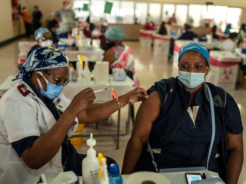 A health care worker is given the Johnson & Johnson COVID-19 vaccine at an assembly hall on the grounds of Charlotte Maxeke Johannesburg Academic Hospital in Johannesburg, South Africa, March 5, 2021. A concerning new variant of the coronavirus, whose mutations evidence a Òbig jump in evolution, is driving a spike in new COVID-19 infections in South Africa, scientists said on Thursday, Nov. 25.