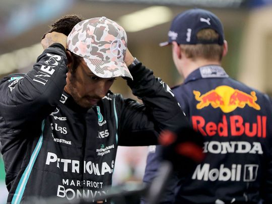 A disappointed Lewis Hamilton alongside Verstappen in Abu Dhabi