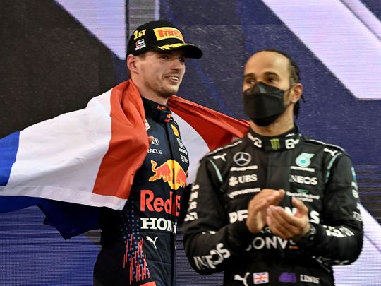 Max Verstappen celebrates as Lewis Hamilton looks on