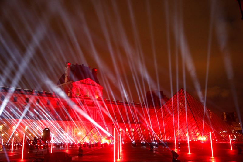 The Louvre Pyramid designed by Chinese-born U.S. architect leoh Ming Pei is illuminated before the ' United at Home ' fundraising live concert by French DJ David Guetta for New Year's eve, in Paris, France, December 29, 2020. Picture taken December 29, 2020. REUTERS/Charles Platiau
