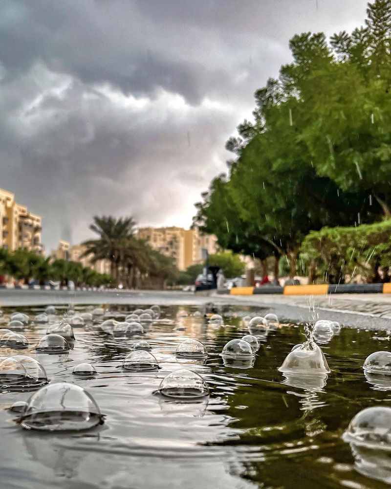 Raindrops make bubbles in puddles of rainwater in Remraam, Dubai.