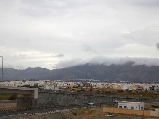 Clouds cover mountain tops as rainy weather is expected in Oman's Al Amirat area, on January 1, 2022. 