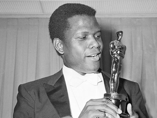 Actor Sidney Poitier poses with his Oscar for best actor for “Lillies of the Field” at the 36th Annual Academy Awards in Santa Monica, California on April 13, 1964. Poitier, the groundbreaking actor and enduring inspiration who transformed how Black people were portrayed on screen, became the first Black actor to win an Academy Award for best lead performance and the first to be a top box-office draw, died Thursday, Jan. 6, 2022. He was 94.