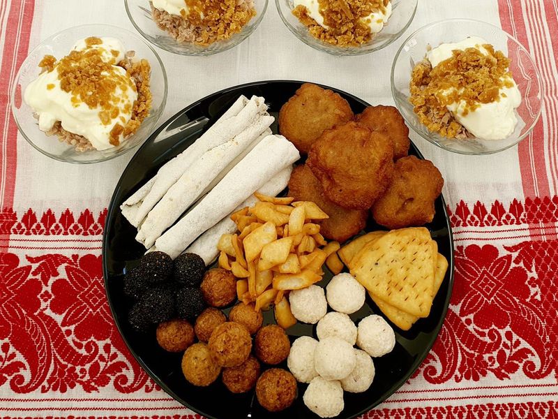 A typical Assamese breakfast - doi chura, pitha and sweet coconut ladoos