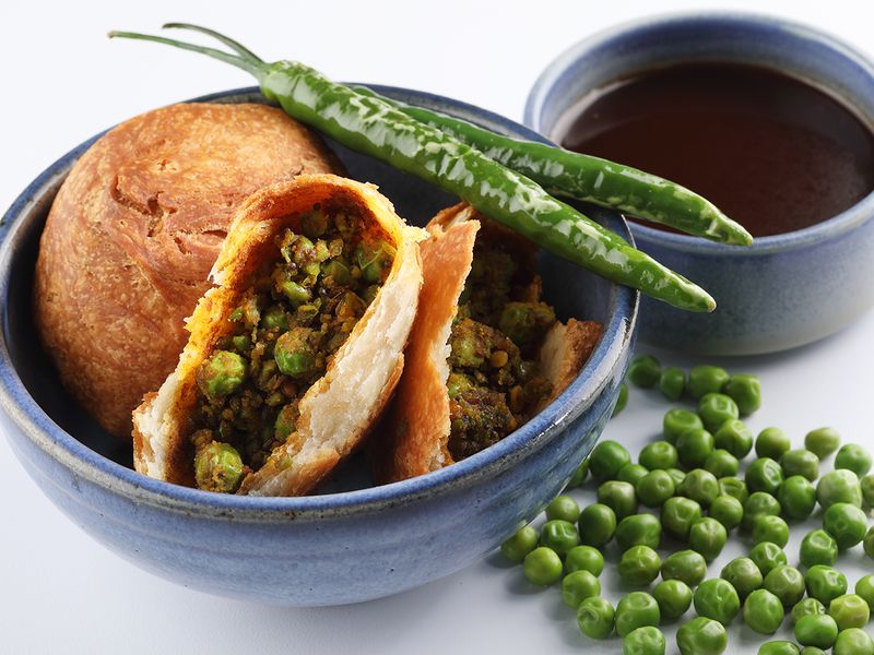 Matar Kachori or a fried savory pastry topped with green peas.  Image used for illustrative purposes only