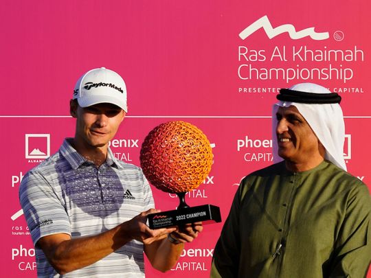 Nicolai Hojgaard with the Ras Al Khaimah Championship trophy alongside Sheikh Saud bin Saqr Al Qasimi, Supreme Council Member and Ruler of Ras Al Khaimah