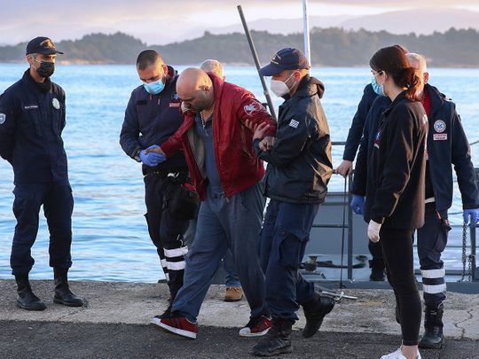 A slightly injured man helped by coast guard officers