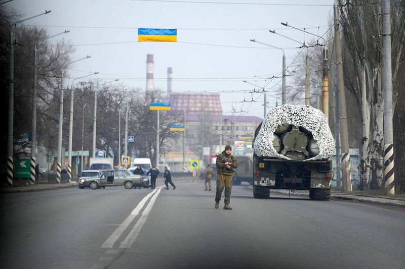 A Ukrainian soldier stands next to a military vehicle on a road in Kramatosrk, eastern Ukraine. 