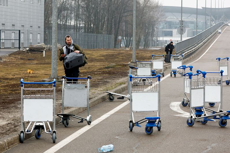 A person walks past luggage carts at Kyiv Airport. 