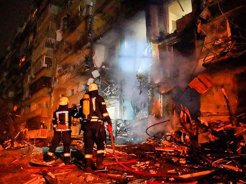 Firefighters inspect the damage at a building following a rocket attack on the city of Kyiv, Ukraine, on Friday, February 25, 2022. 