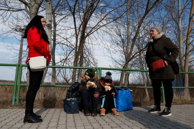People wait at a border crossing as they flee from Ukraine to Hungary.