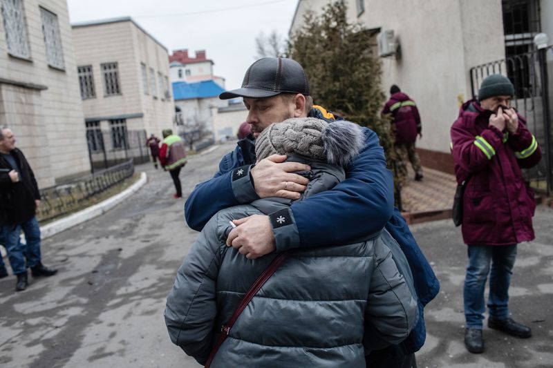 Residents react after inspecting a fire damaged building following a blast at around 4am during Russian artillery strikes in Kyiv, Ukraine.