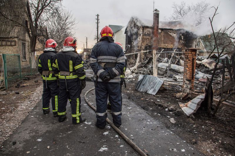 Ukrainian firefighters look at fragments of a downed aircraft seen in in Kyiv.