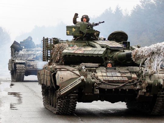 Ukrainian servicemen ride on tanks