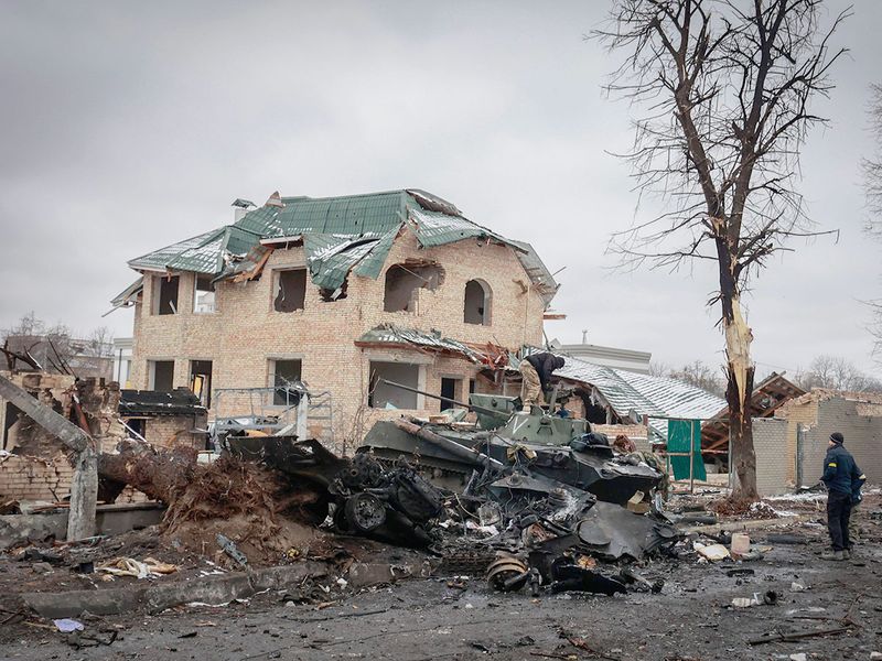 A man looks at the gutted remains of Russian military vehicles on a road in the town of Bucha, close to the capital Kyiv, Ukraine, Tuesday, March 1, 2022. 